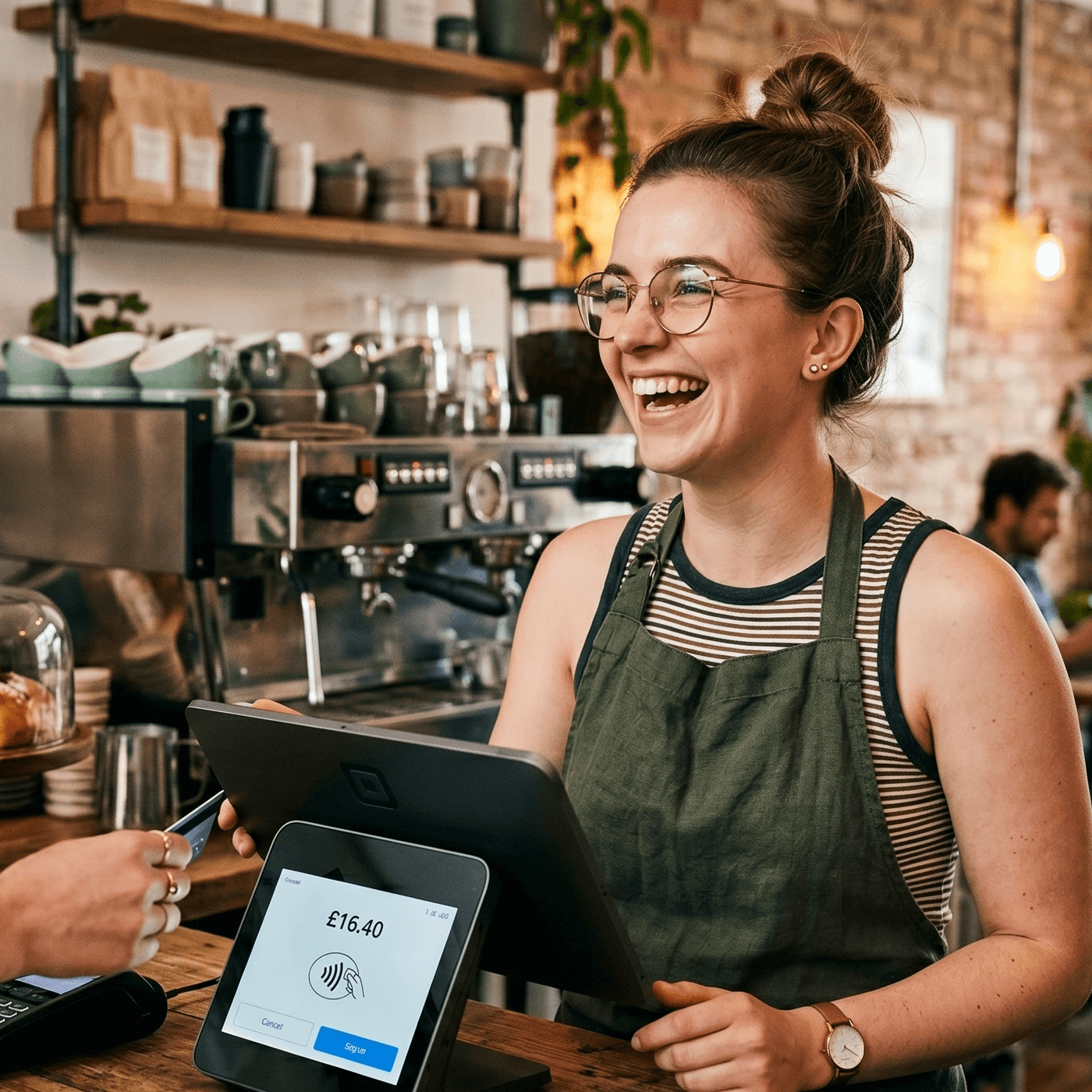 A happy barista at the till